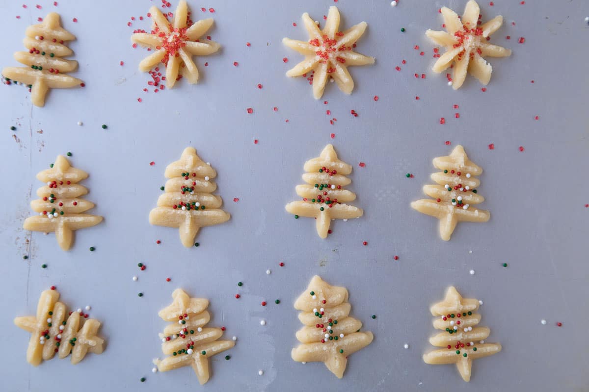 uncooked spritz cookies topped with red and green sprinkles.