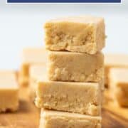 stack of four pieces of peanut butter fudge on a wooden serving tray.