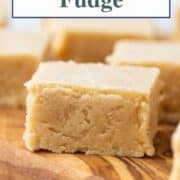 square pieces of peanut butter fudge on a wooden serving board.