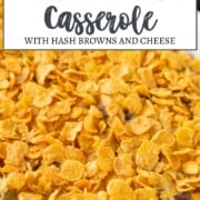 corn flakes on top of a hash brown casserole in a casserole dish.