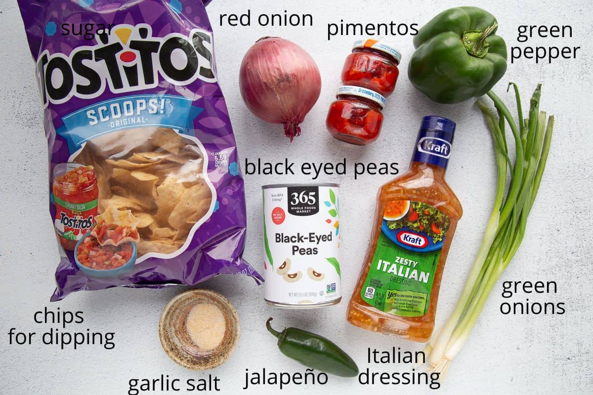 black eyed peas, tortilla chips, onion, and more ingredients on a white table.