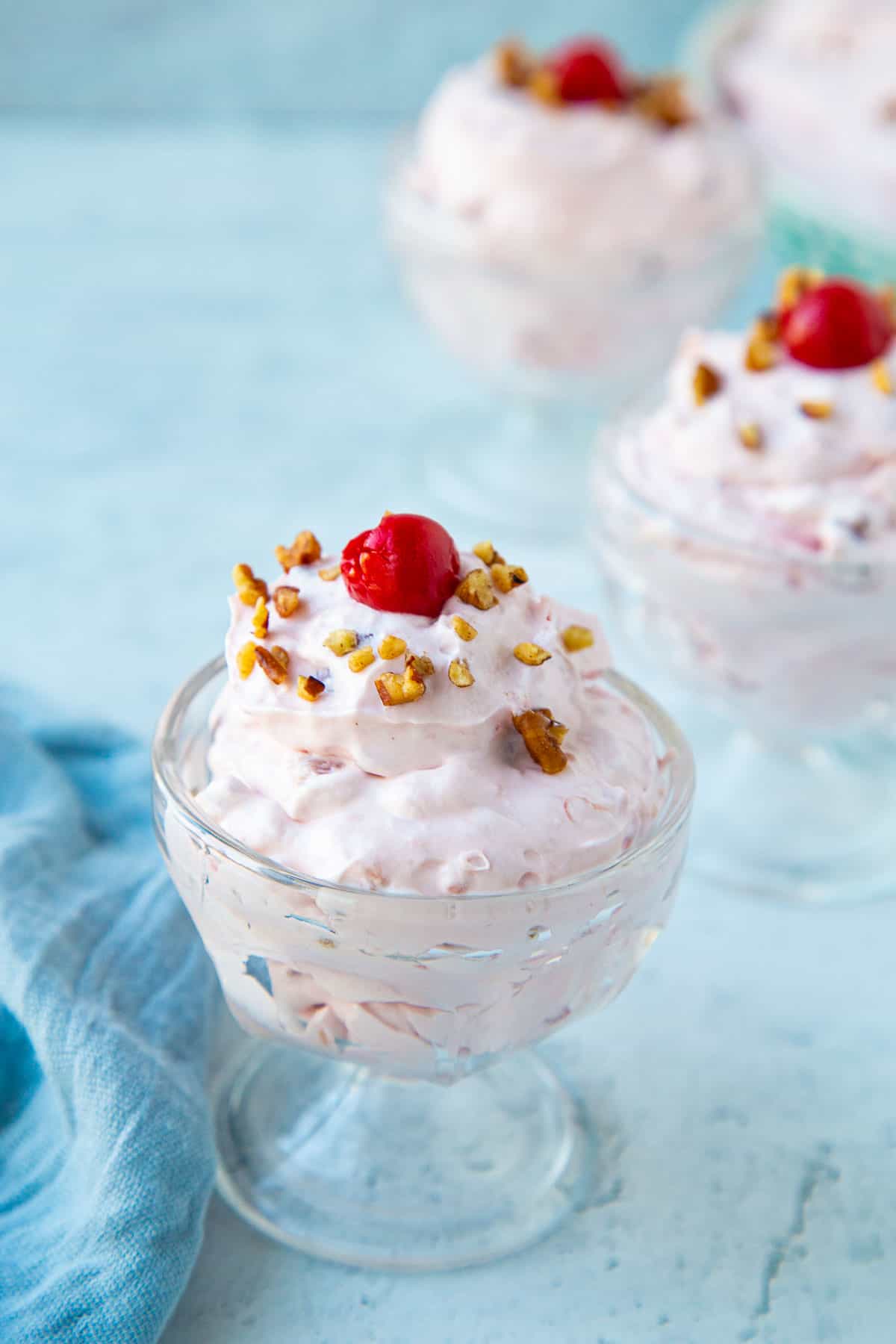 cherry salad in mini parfait dishes, topped with cherries and pecans.