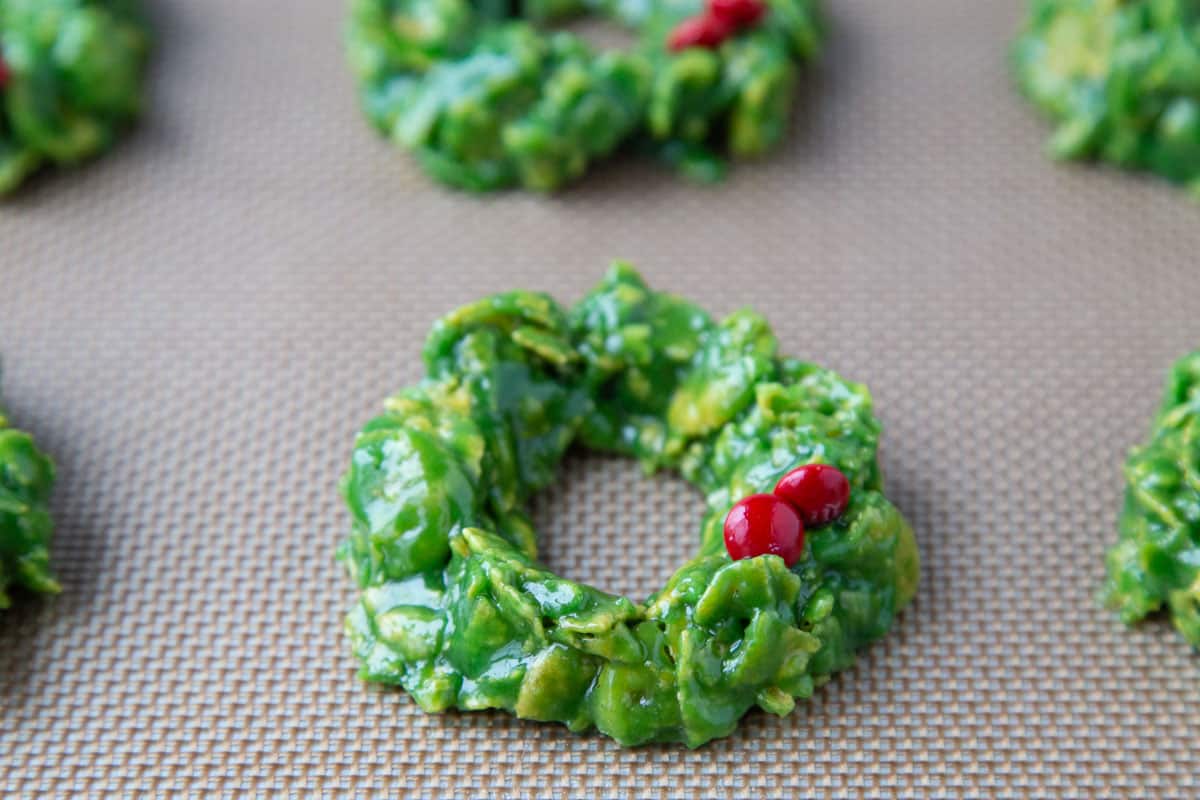 corn flake christmas wreaths with red M&Ms as holly on a baking sheet.