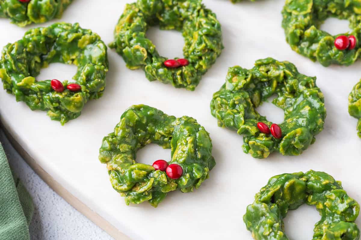 corn flake candy wreaths with mini red M&Ms for holly on a white platter.