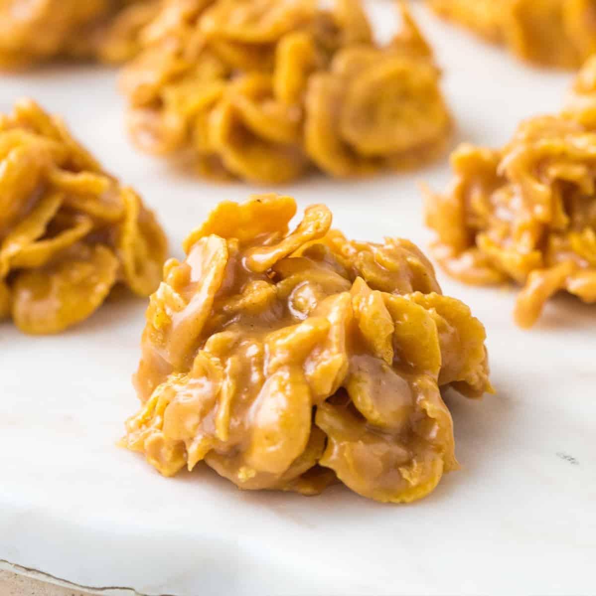 corn flake candy clusters on a white marble tray.