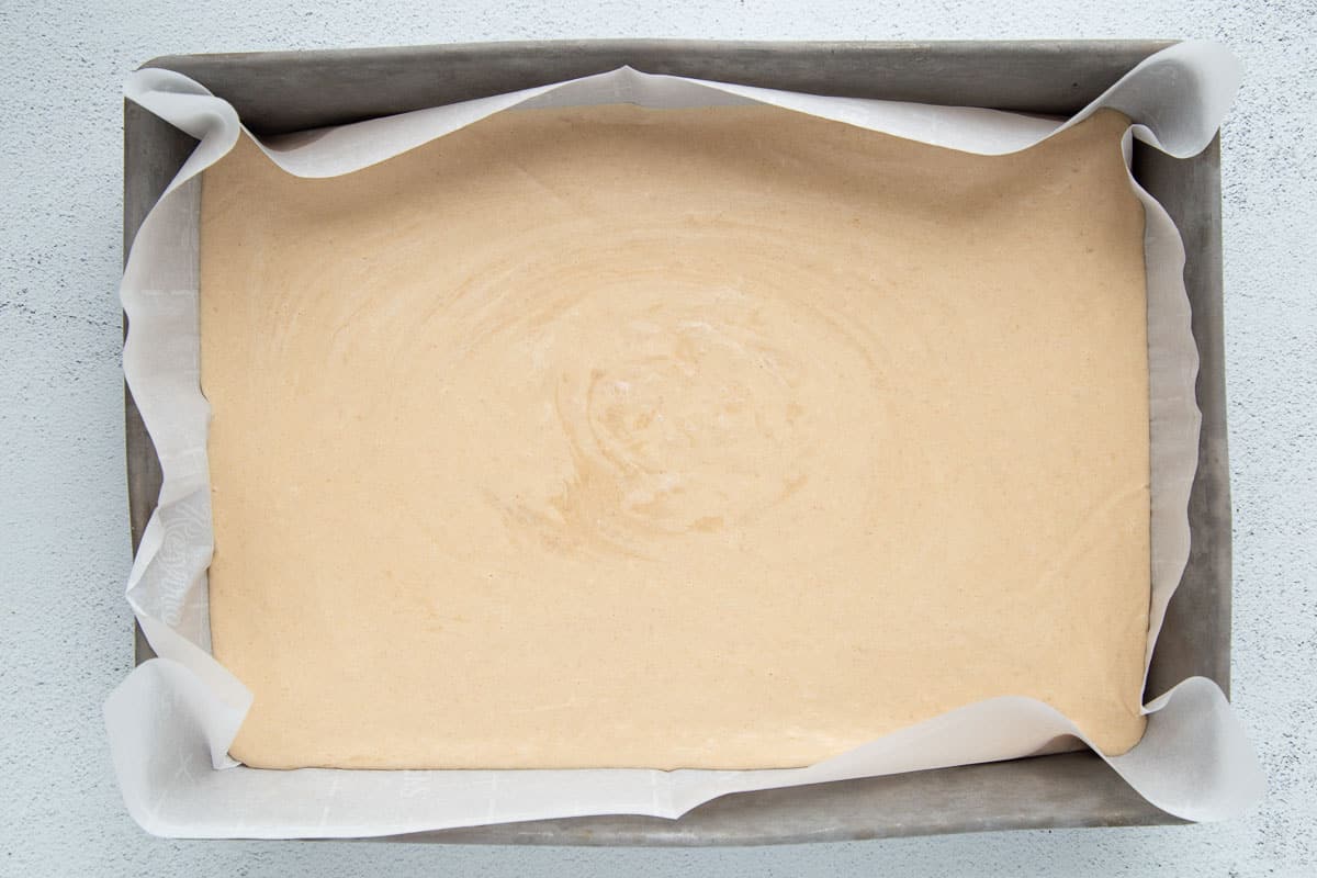 peanut butter fudge in a metal pan lined with parchment paper.