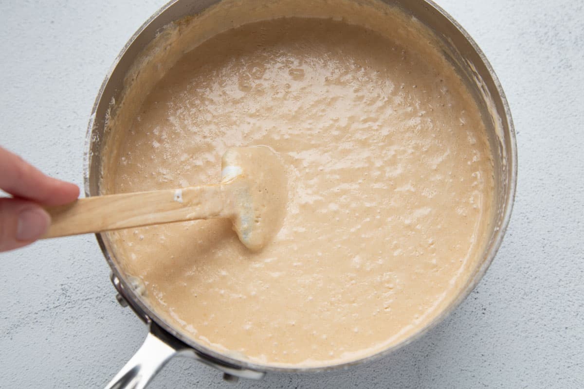 smooth peanut butter mixture in a saucepan with a spatula.
