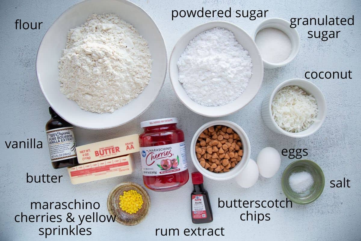 flour, sugar, butter, and other cookie ingredients on a white table.