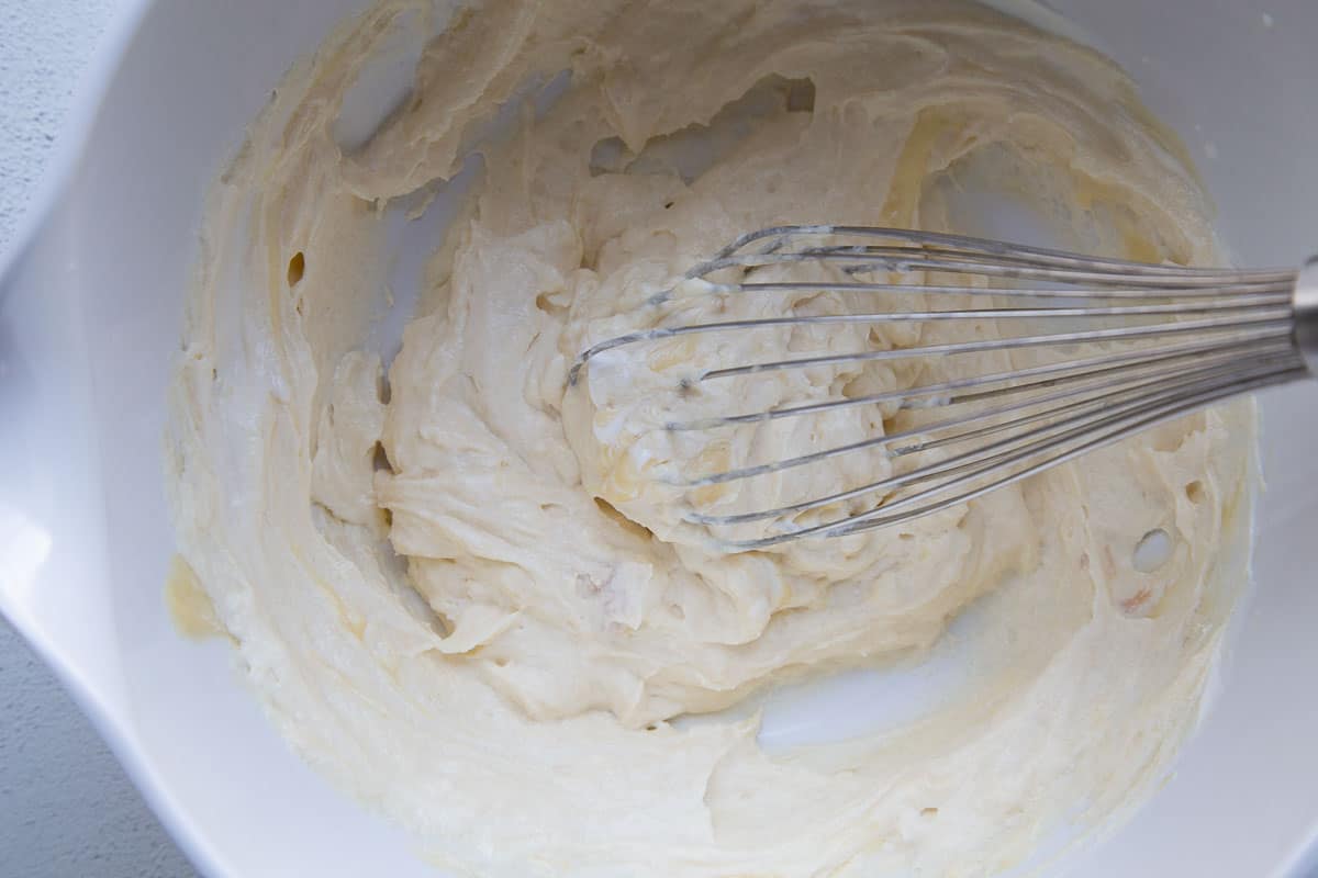 sour cream mixture in a white bowl with a whisk.