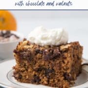 slice of old fashioned date cake with a dollop of whipped cream on top, sitting on a white plate.