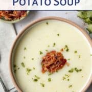 bowl of potato soup topped with chopped bacon and parsley.