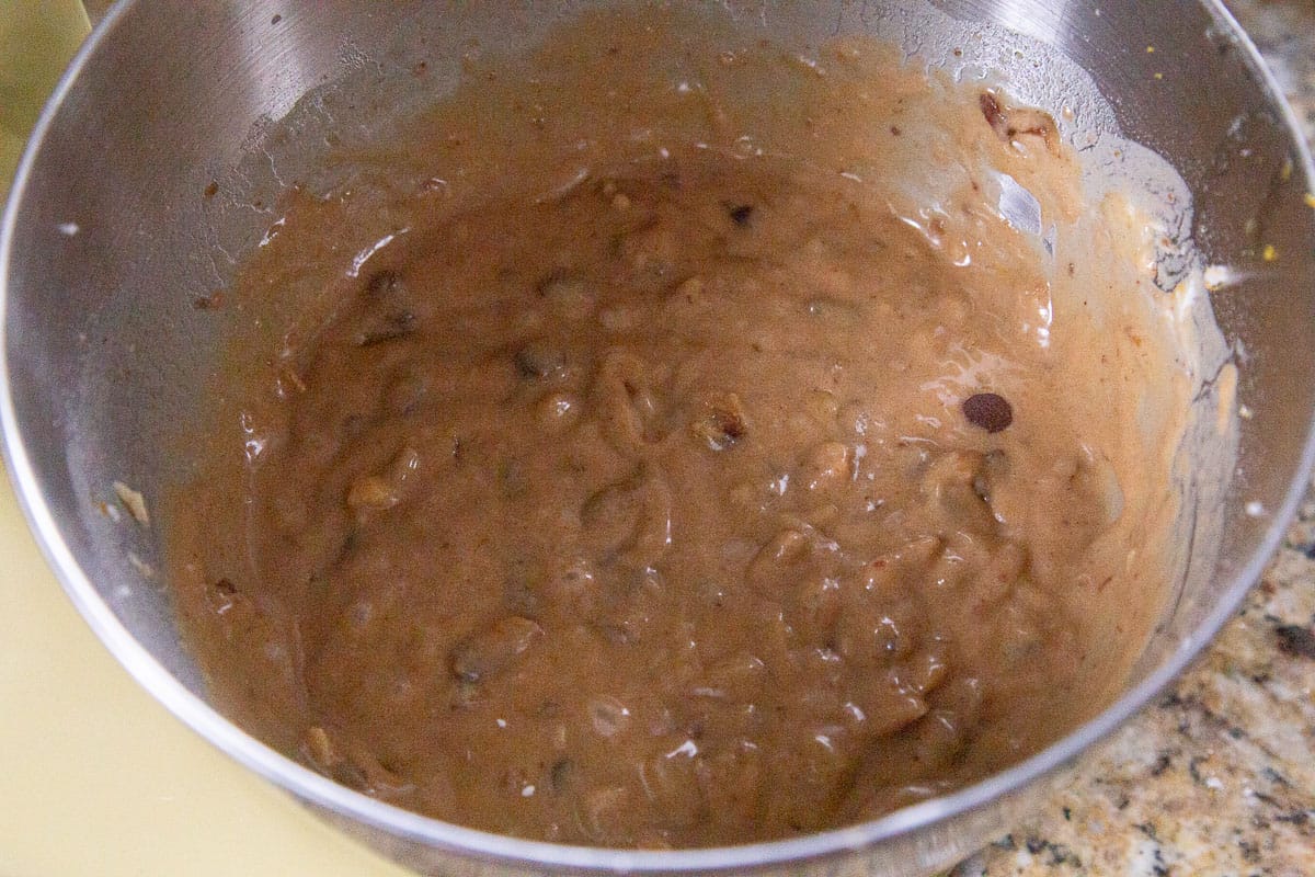 brown cake batter in a metal bowl.