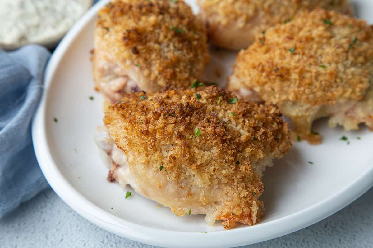 white platter with breadcrumb topped chicken thighs.