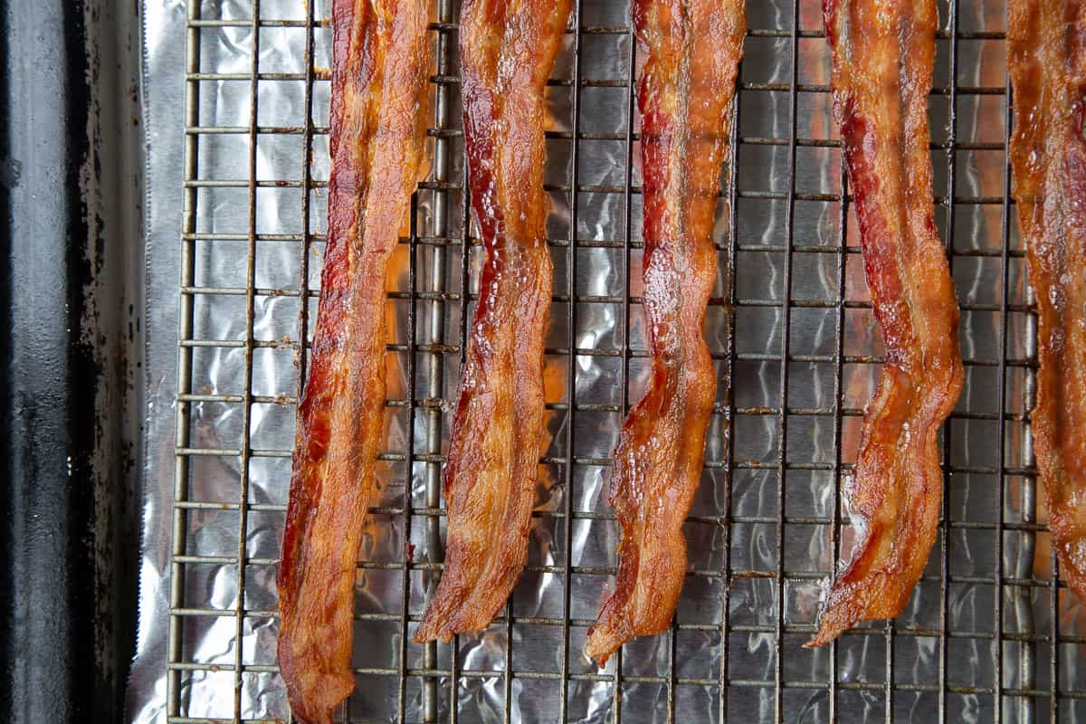 strips of crispy cooked bacon on a wire rack on top of a sheet pan.