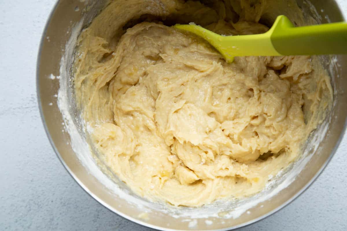 coffee cake batter in a metal bowl with a yellow spatula.