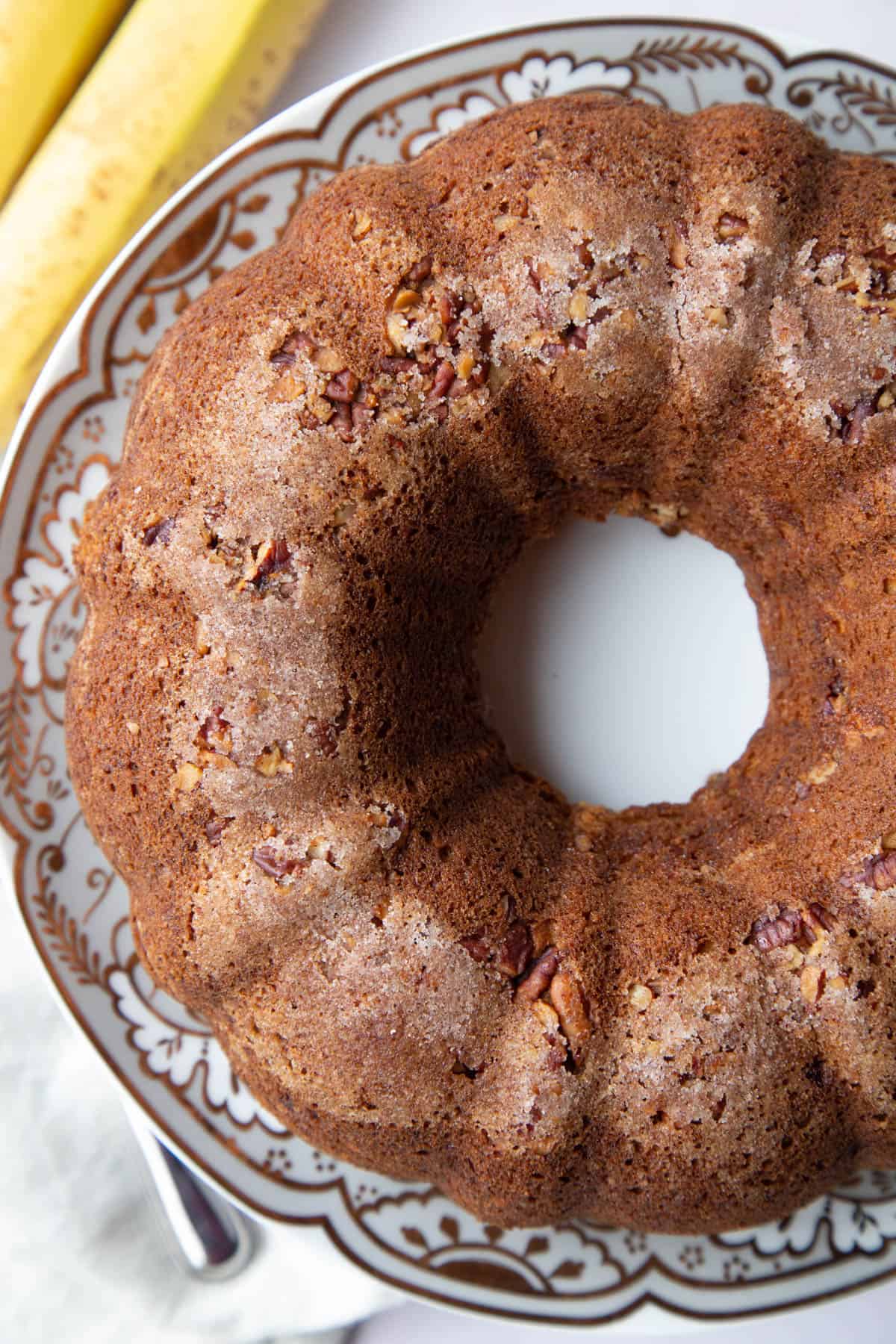 whole banana coffee cake on a decorative cake stand.