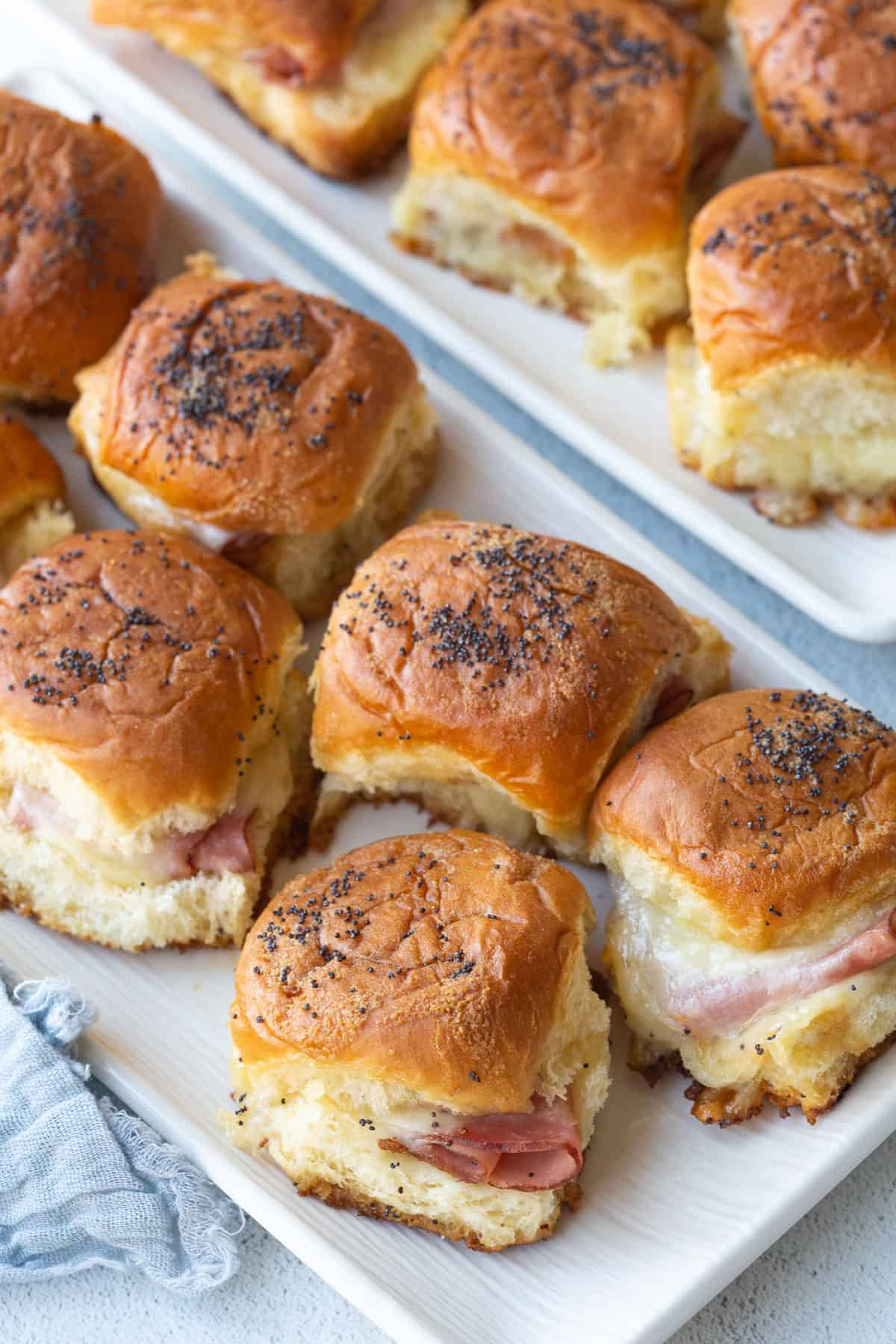 hawaiian roll sliders on two rectangular white platters.