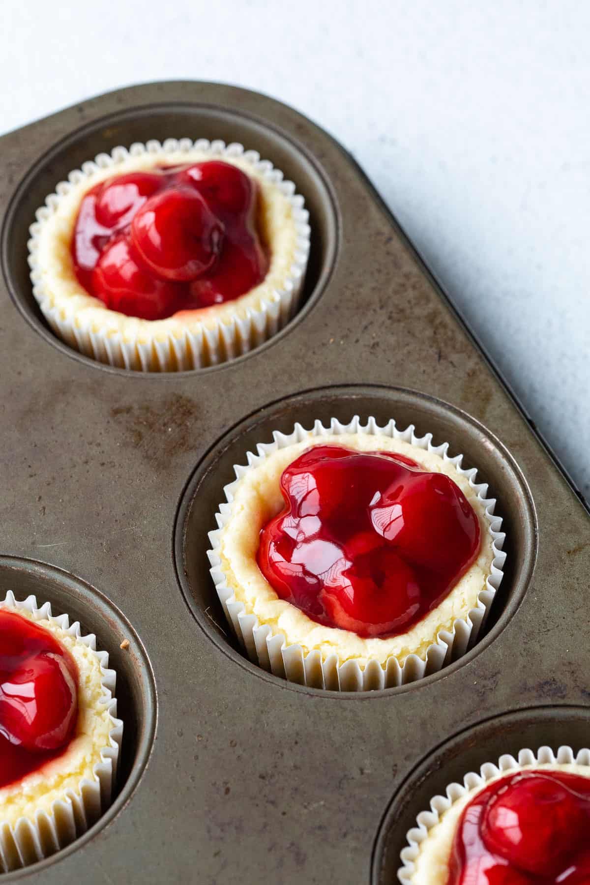 mini cherry cheesecakes in a muffin tin.