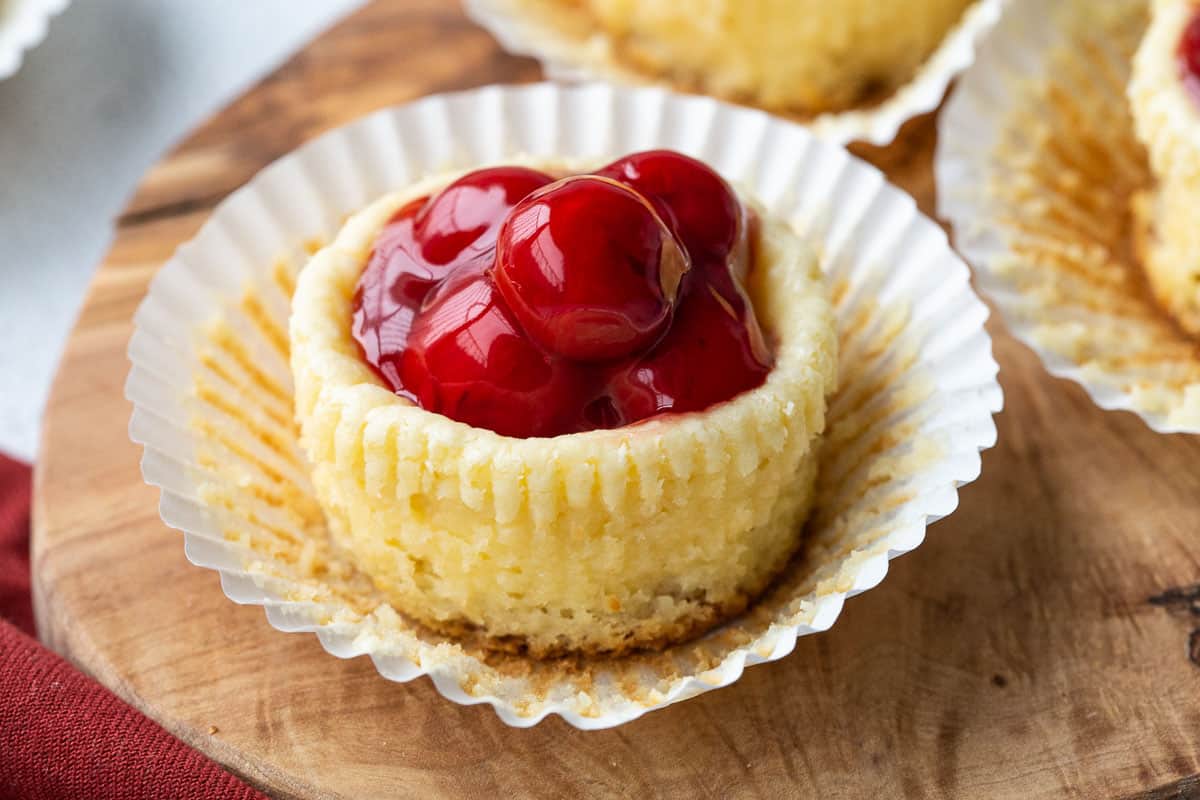 mini cherry cheesecake in a white paper cupcake liner.