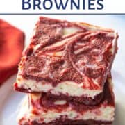 three red velvet brownies stacked on a white plate.