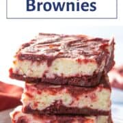 red velvet brownies stacked on a white plate.