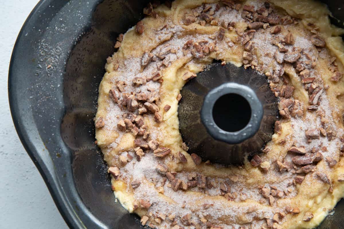 batter topped with pecan streusel in a bundt pan.