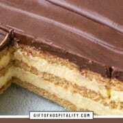 cross section of a layered cake with layers of graham crackers and vanilla pudding, with chocolate frosting on top.