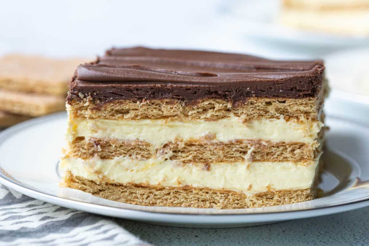 layered eclair cake with layers of graham crackers, vanilla custard, and chocolate frosting.