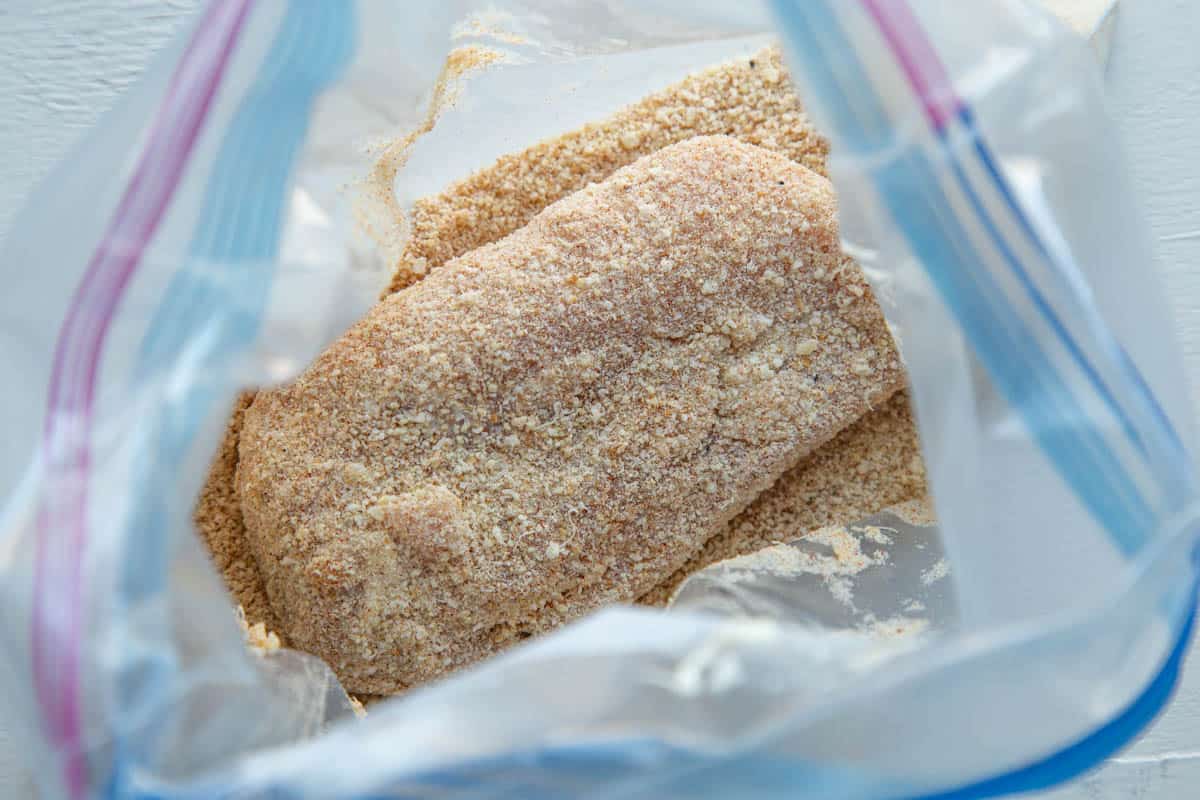 breadcrumb coated chicken breast in a large plastic bag.