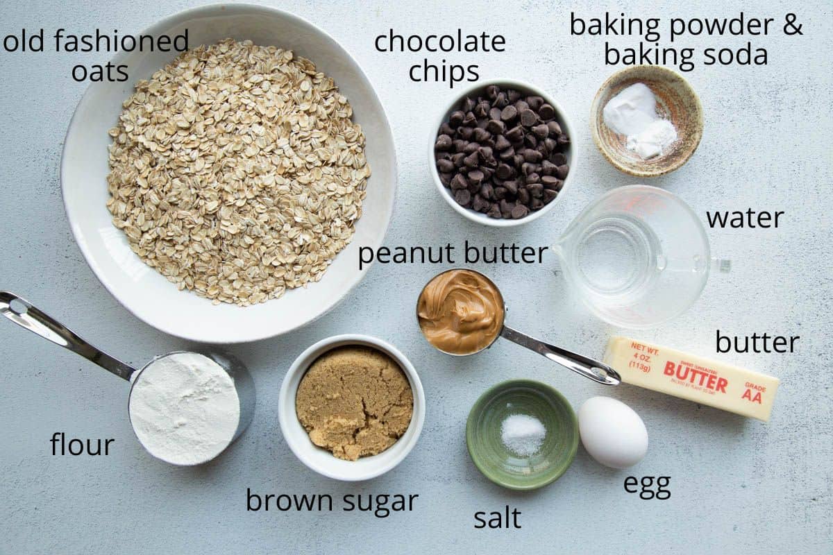 oats, chocolate chips, peanut butter, and other ingredients on a white table.