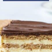 layered chocolate eclair cake with chocolate frosting on a white plate.