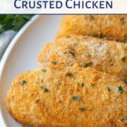 baked parmesan crusted chicken breasts on a white platter.