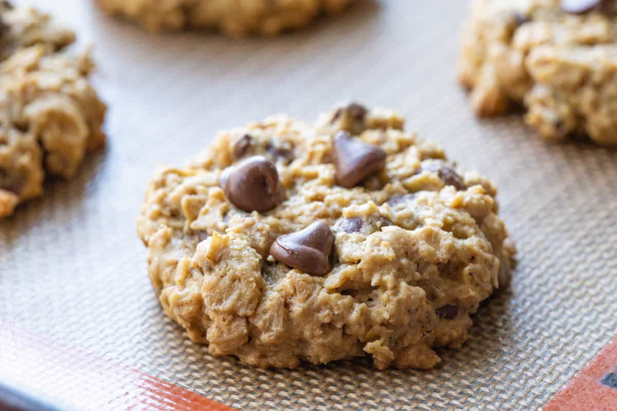 peanut butter oatmeal cookie with chocolate chips on a silicone mat.