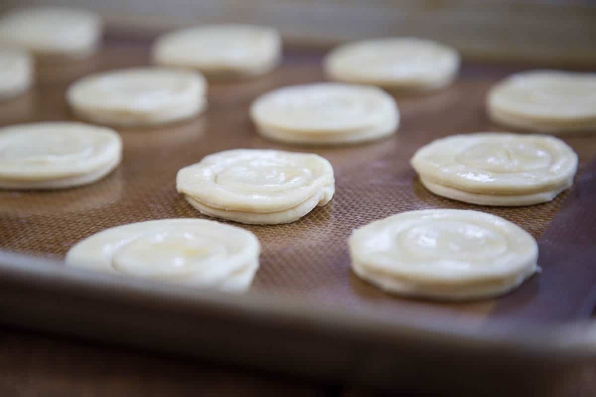 unbaked puff pastry rounds on a baking sheet.