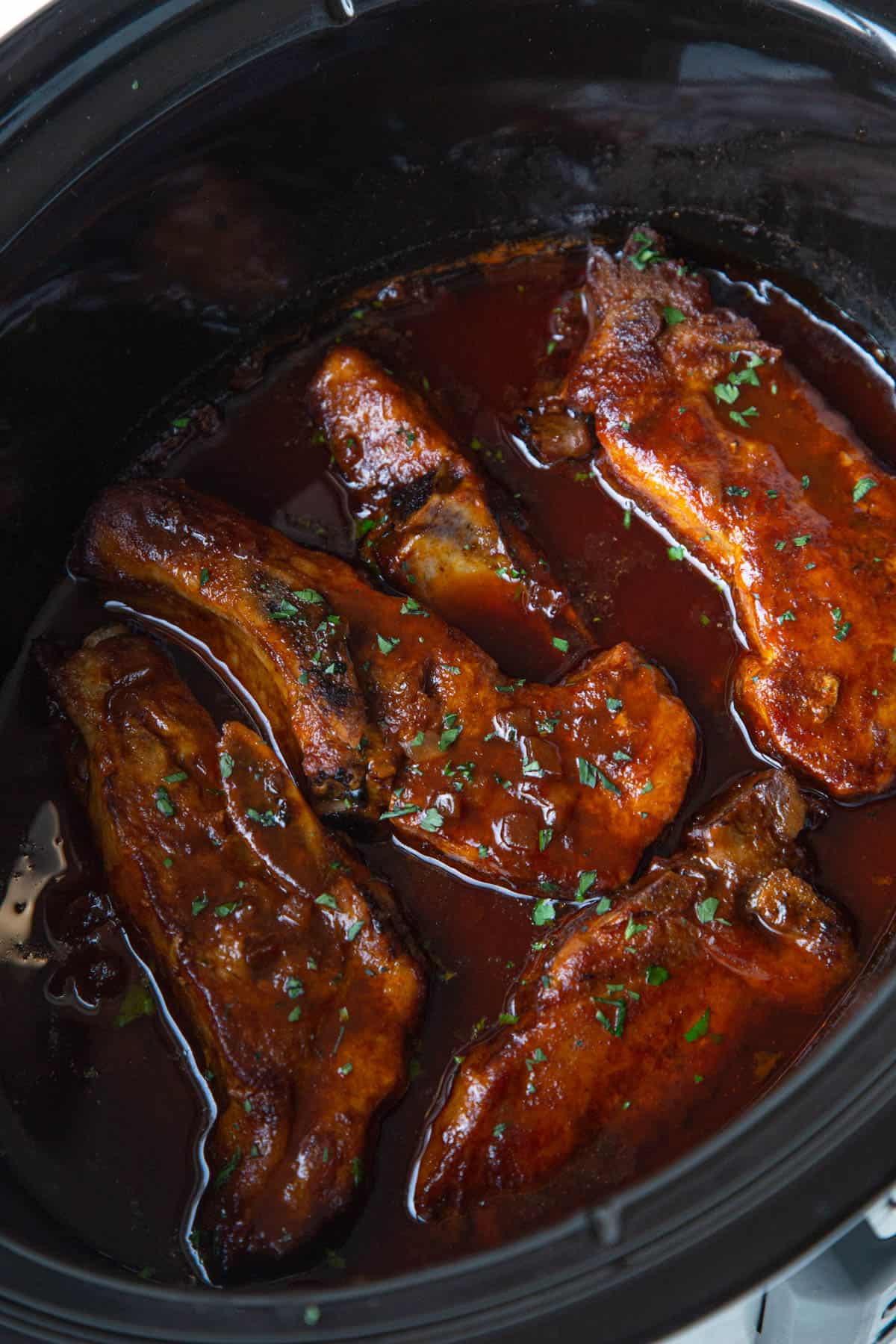 country style ribs coated in bbq sauce in a crockpot.