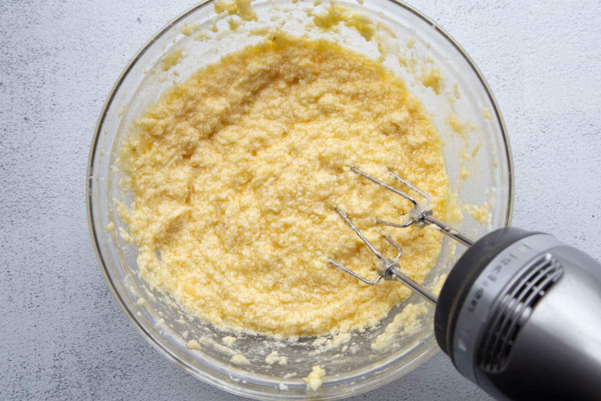 egg and banana mixture in a glass bowl with a hand mixer.