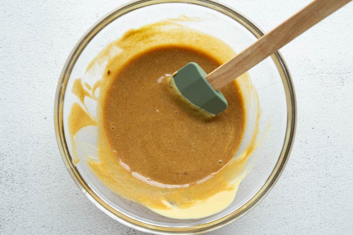 brown sugar and dijon mustard in a glass bowl with a spatula.