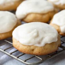 pineapple cookies with vanilla frosting on a wire rack.