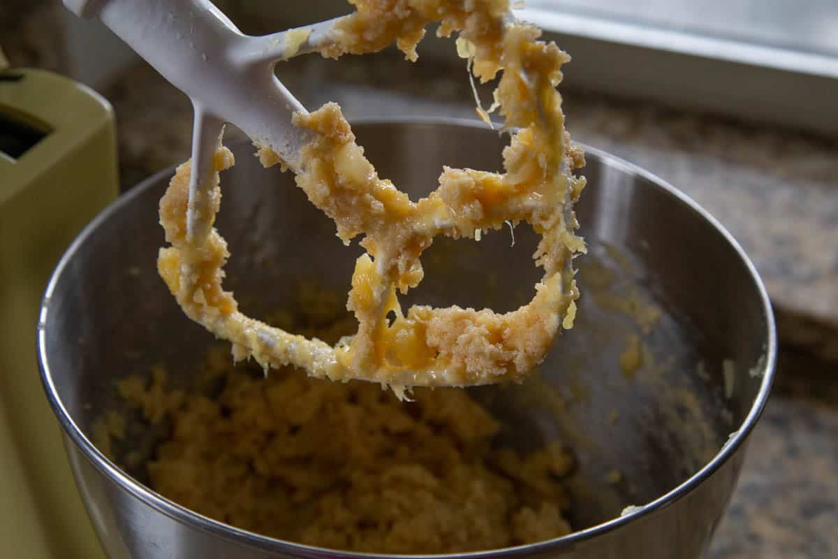 cookie dough in process in a stand mixer with a paddle attachment.