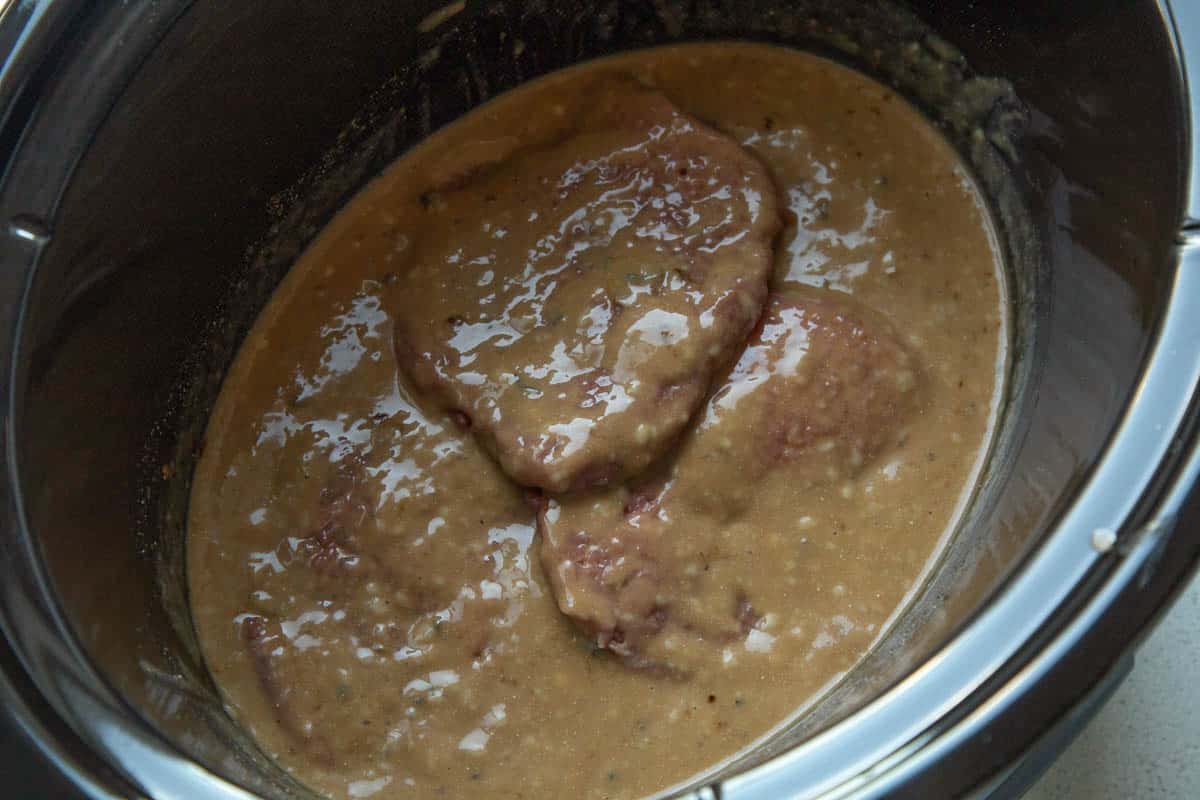 raw cube steaks in gravy in a slow cooker.