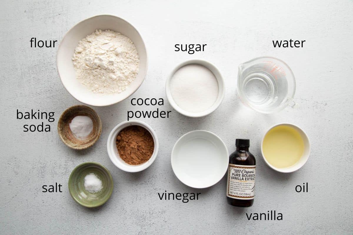 flour, cocoa powder, sugar, and other ingredients on a white table.