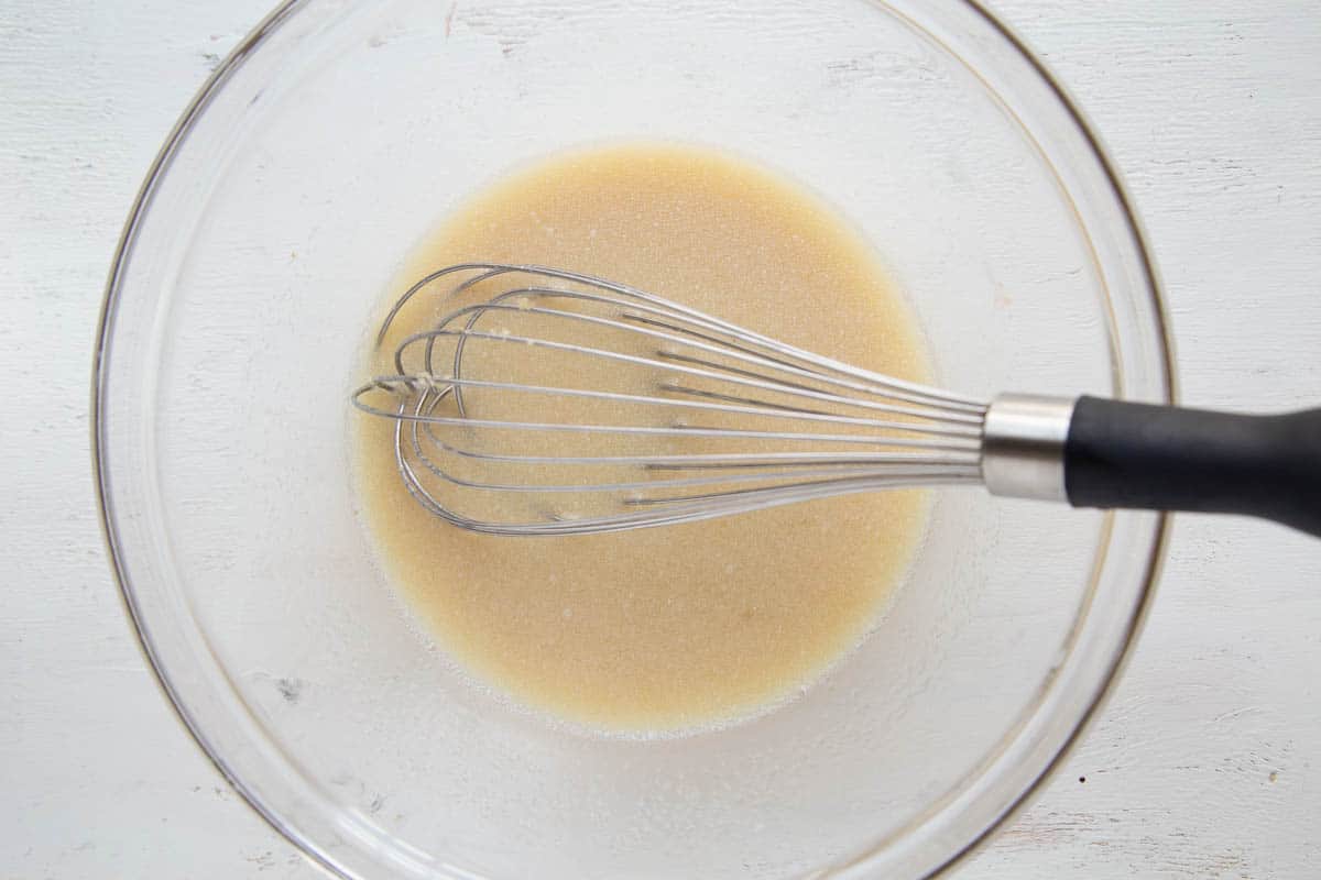 wet ingredients in a glass bowl with a whisk.