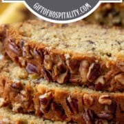slices of banana bread stacked up, topped with pecans.