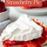 slice of strawberry pie topped with whipped topping.