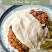 chicken fried steak topped with white gravy over mashed potatoes.