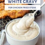 a spoon holding white gravy.