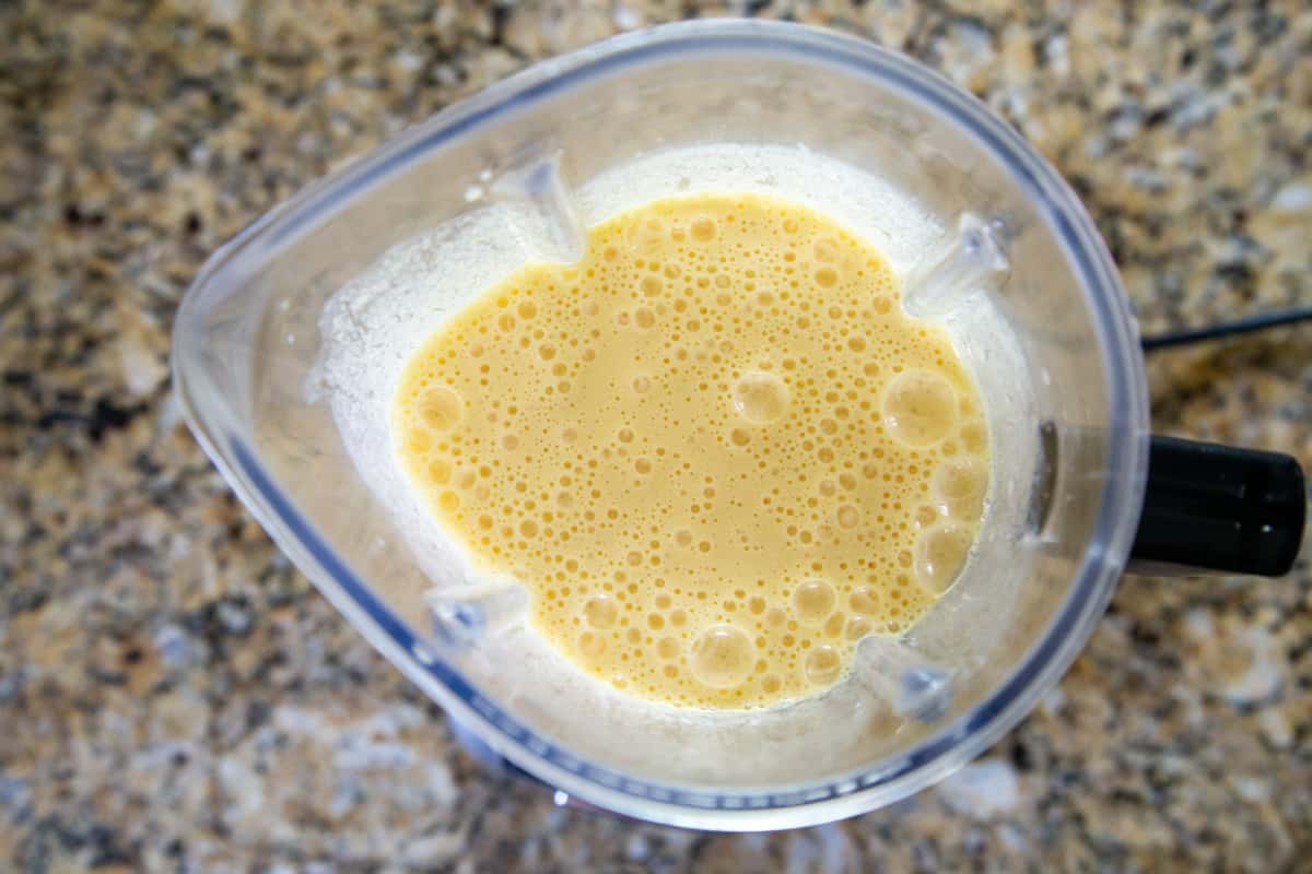 creamy orange beverage with frothy bubbles in a blender.