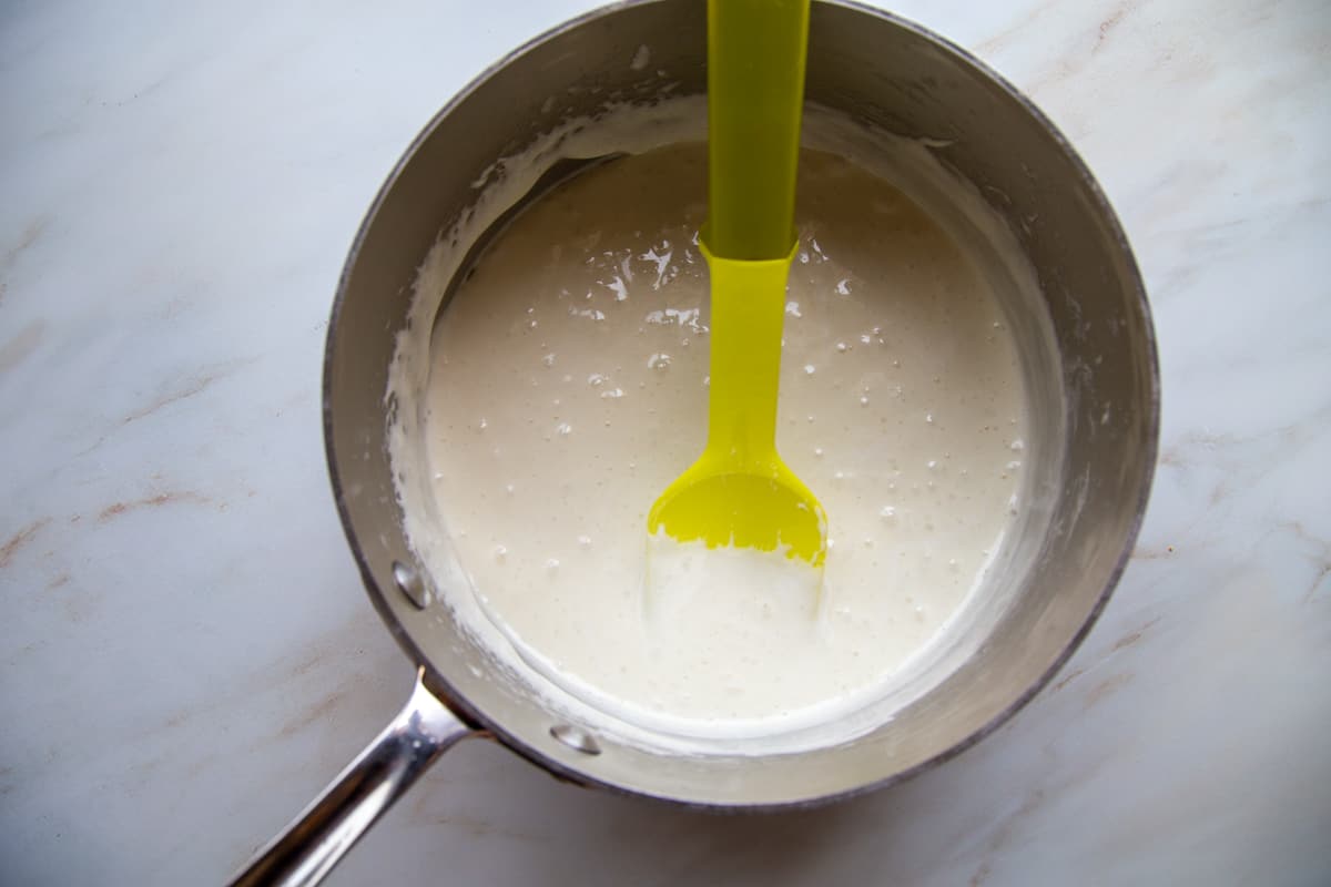 melted marshmallows in a saucepan with a yellow spatula.