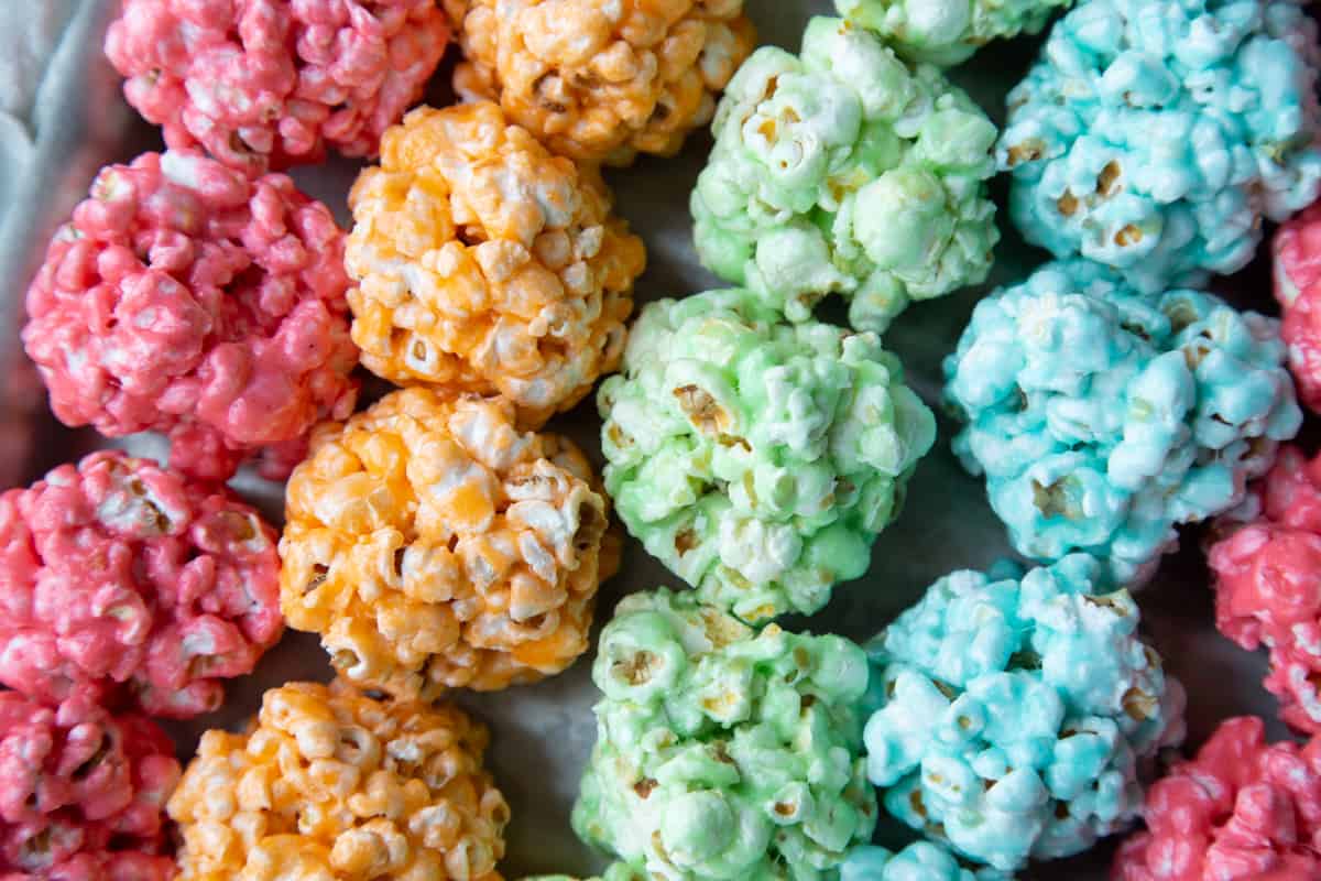 red, orange, green, and blue popcorn balls lined up in rows.
