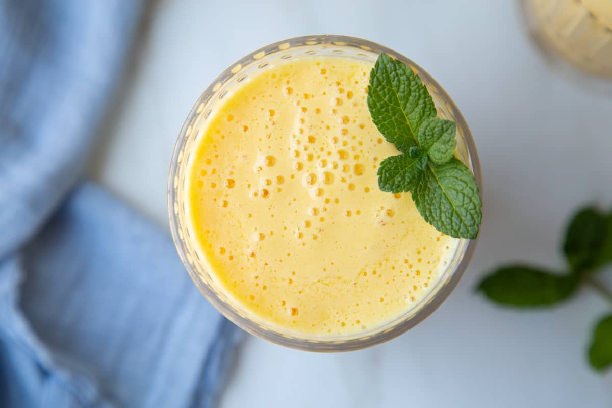 top down view of an orange julius in a glass, garnished with fresh mint.